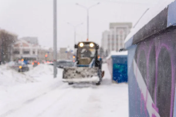 Blurred background - city during snowfall and snow removal loade — Stock Image Blurred background - city during snowfall and snow removal loade Stock Image