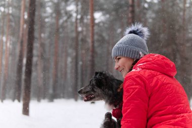 Genç bir kadın kış ormanında köpeğini düşünür.