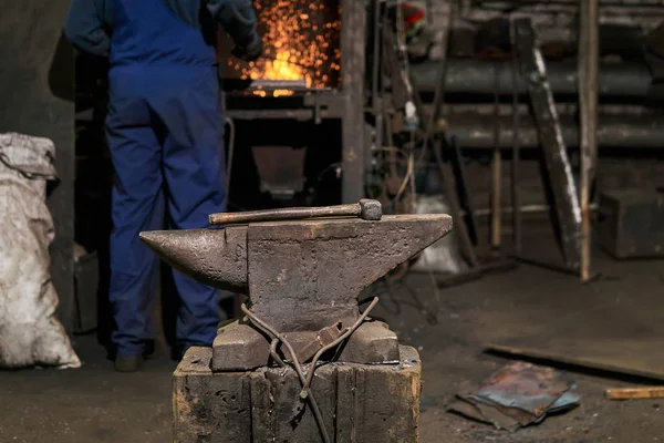 The hammer lies on the anvil in the forge while the blacksmith w — 스톡 사진