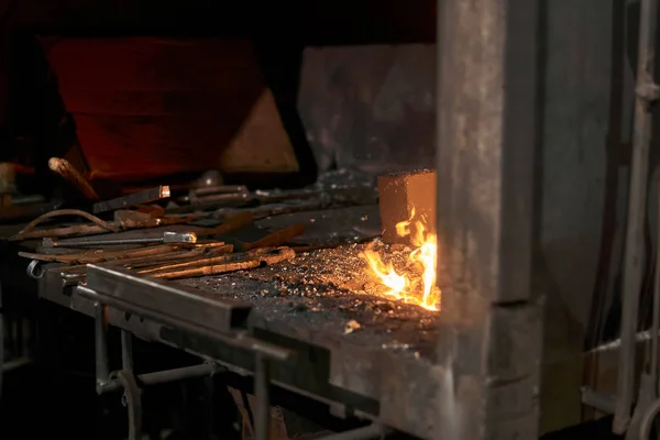 Forge furnace with burning flame and blacksmith tools — 图库照片