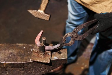 blacksmith forges a horseshoe, close-up