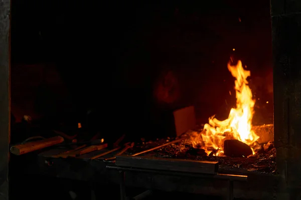 Horno herrero con fuego ardiente y herramientas de forja mintiendo nea — Foto de Stock