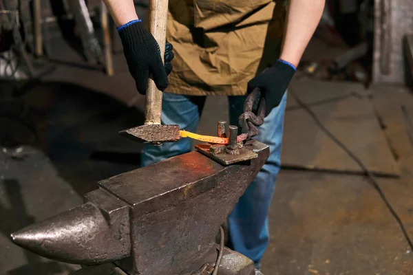 blacksmith forges a horseshoe, close-up