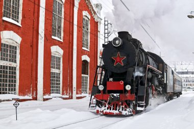 buharlı lokomotif kışın tren istasyonundan geçiyor