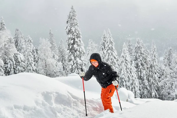 Mujer trekking en el bosque de montaña de invierno durante una nevada —  Fotos de Stock