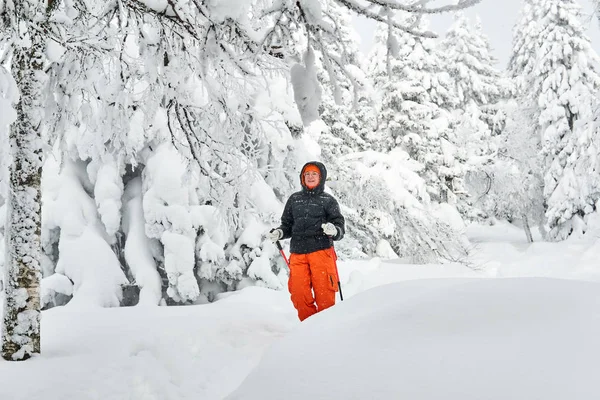 Mujer trekking en el bosque de invierno durante las nevadas —  Fotos de Stock