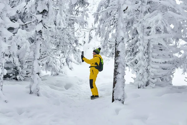 Mujer viajero en invierno bosque registros de vídeo por teléfono inteligente — Foto de Stock