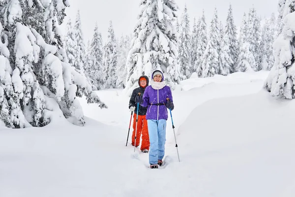 Dos mujeres excursionistas de turistas en un bosque de montaña de invierno — Foto de Stock