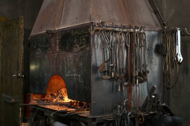 forge furnace with burning flame and blacksmith tools 