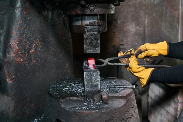 女铁匠在车间里加工带有电锤的红色热工件 — 图库照片