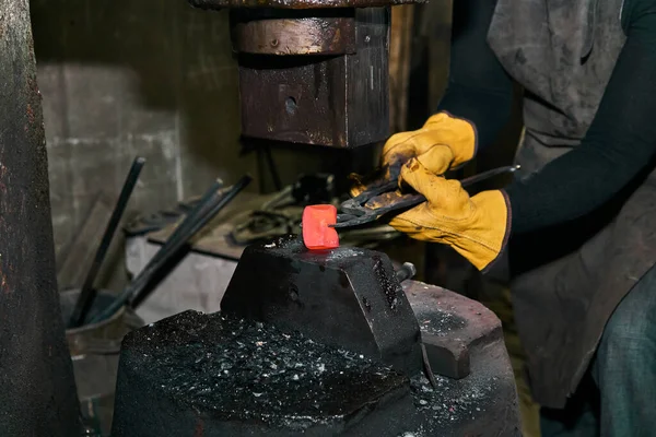 女金属艺术家在车间里加工带有电锤的红色热工件 — 图库照片