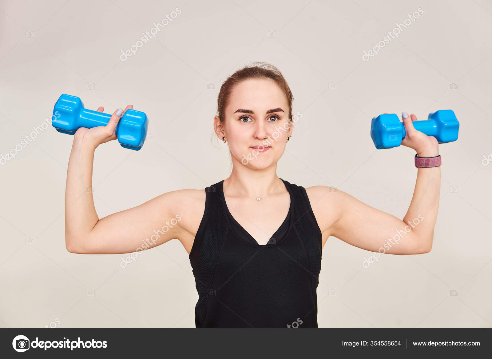 Young Petite Woman Performs Exercise Dumbbells Half Length Portrait Light  Stock Photo by ©Haritonoff 354558654