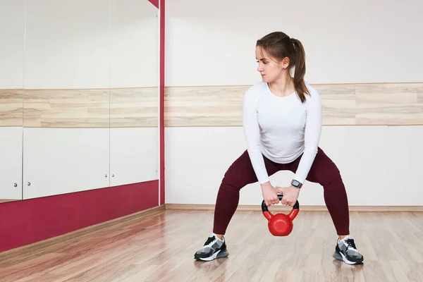 Joven Petite Mujer Está Entrenando Con Kettlebell Amplio Gimnasio Mirando — Foto de Stock