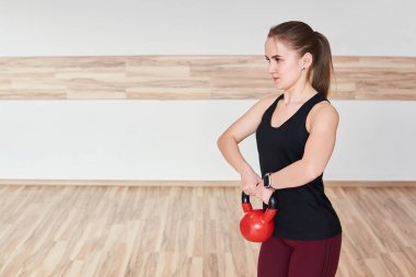 Genç bayan jide kettlebell ile egzersiz yapıyor.