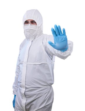 Tek kullanımlık anti-bakteriyel izolasyon giysisindeki erkek epidemiyoloji uzmanı bir eli beyaz arka planda izole edilmiş yasaklayıcı bir jest gösteriyor.