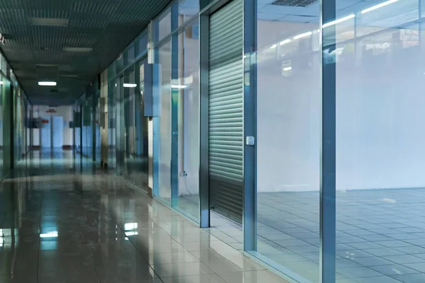 Kiracıları olmayan, boş perakende yeri olan loş, terk edilmiş alışveriş merkezi koridoru