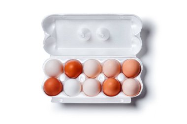 Beyazdan kahverengiye farklı tonlarda yumurtalar tek bir yumurta kasasında toplanır, beyaz arka planda, yatay üst görünümde izole edilir.,