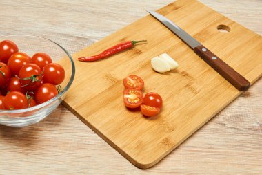 Kiraz domatesleri, kırmızı biber, sarımsak ve mutfak bıçağıyla dolu bir hayat. 