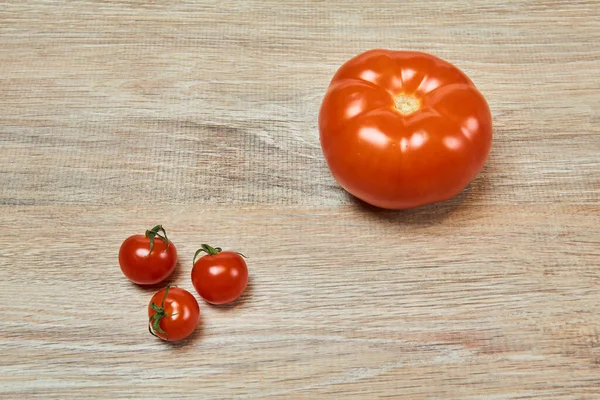 Tres Tomates Cherry Pequeños Junto Tomate Ordinario Grande Sobre Mesa — Foto de Stock