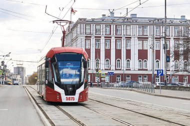 Perm, Rusya - 27 Nisan 2020: Şehir yönetiminin tarihi binasının arka planında modern tramvay