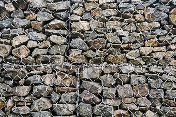 arkaplan - granit kayalarla altıgen tel örgü örülmüş gabion duvar