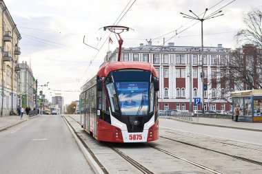 Perm, Rusya - 27 Nisan 2020: Şehir yönetiminin tarihi binasının arka planında modern tramvay