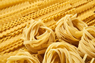 Kuru makarna tagliatelle ve mafaldini altın arka plan