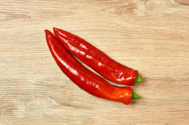 Masanın üzerinde iki kapsül kırmızı biber yatıyor.
