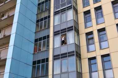 Perm, Rusya - 08 Mayıs 2020: Mahalle sakinleri çok katlı bir apartmanın penceresini yıkıyorlar.