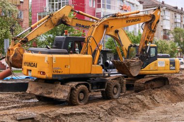 Perma, Rusya - 22 Mayıs. 2020: bir şehir yolunun tadilatı sırasında tekerlekli ve sürüngen kazıcıları