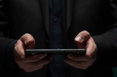 Adam akıllı telefonu tutuyor ve mesaj yazıyor.