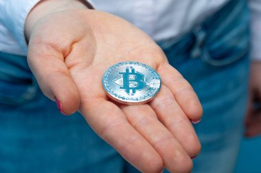 Kimliği belirsiz genç bir kadının elinde Bitcoin var.