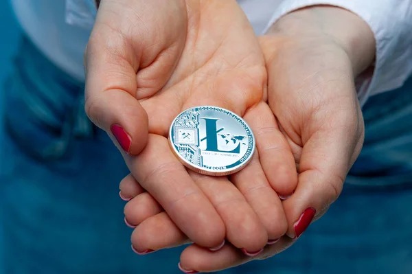 Une jeune femme non identifiée tient une litecoin — Photo