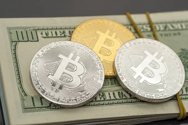 Monedas de Bitcoin se encuentran en pilas de cien dólares — Foto de Stock