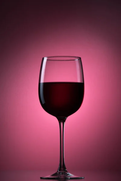 Czerwony jagodowy napój lub czerwone wino do szklanego kielicha na tle. — Zdjęcie stockowe