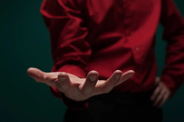 Jovem de camisa vermelha segura um objeto invisível — Fotografia de Stock