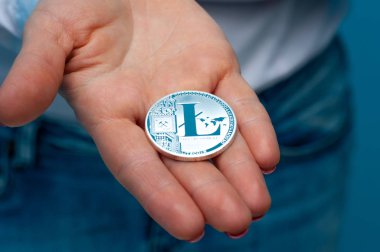 Kimliği belirsiz genç bir kadın litekoin tutuyor.