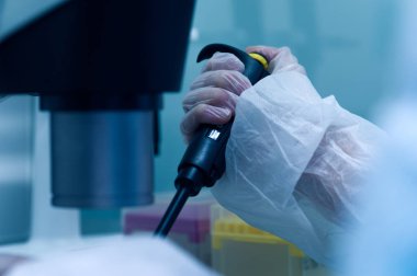 Unidentified technicians hand in protective clothing