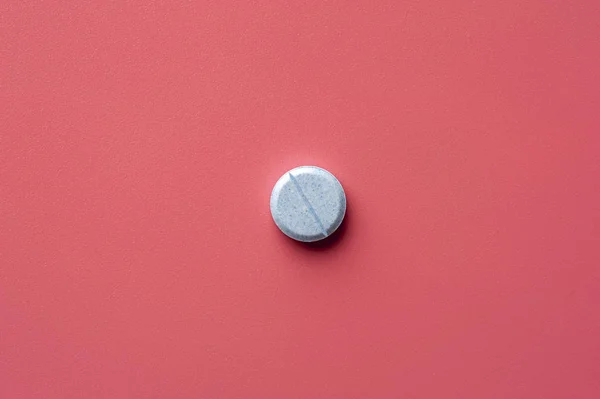 Close-up of one pill lies on a pink surface — 图库照片