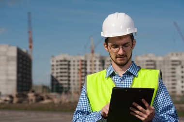 Planlı Yeşil Yelekli Genç Mühendis Portresi