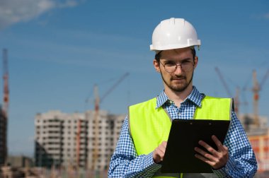 Planlı Yeşil Yelekli Genç Mühendis Portresi