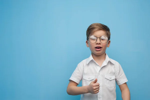 Vicces kis fehér fiú szemüvegben, kék háttérrel.. — Stock Fotó