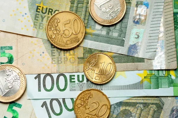 Billetes y monedas en euros de primer plano se encuentran uno al lado del otro — Foto de Stock