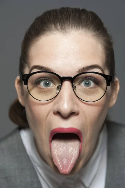 Mujer joven divertida mostrando su lengua — Foto de Stock