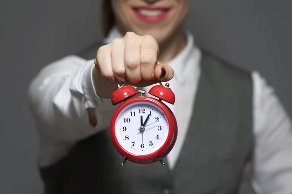 Close-up de jovem empresária ou funcionário de escritório segurando relógio vermelho nas mãos — Fotografia de Stock