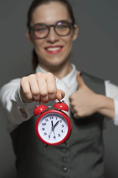 Close-up de jovem empresária ou funcionário de escritório segurando relógio vermelho nas mãos — Fotografia de Stock