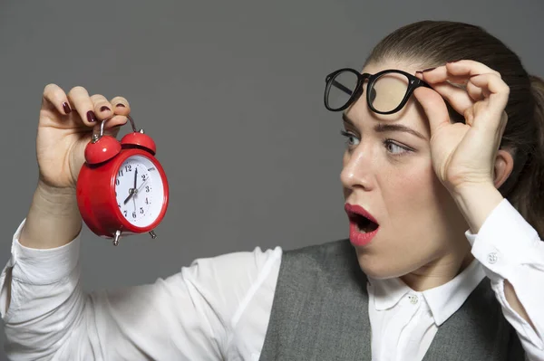 Atractive businesswoman with an amazed face and holding clock Stock Photo
