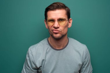 Portrait of funny positive young man in glasses