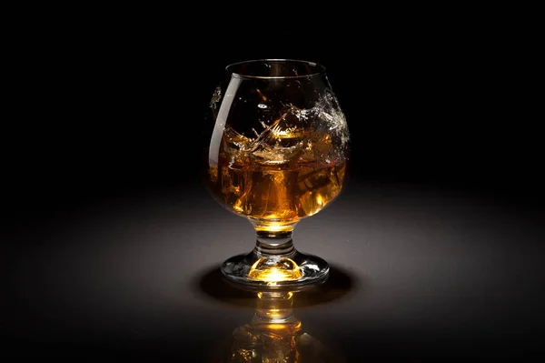 Ice cube fall and splash in beautiful glass goblet — Stock Photo, Image