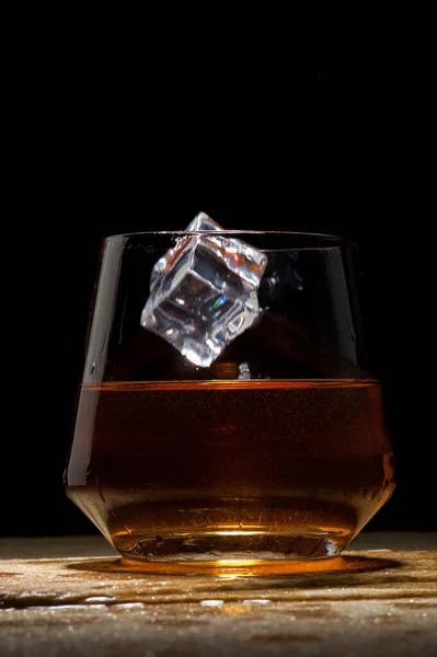 Close-up vierkante ijsblokje valt in een glas — Stockfoto